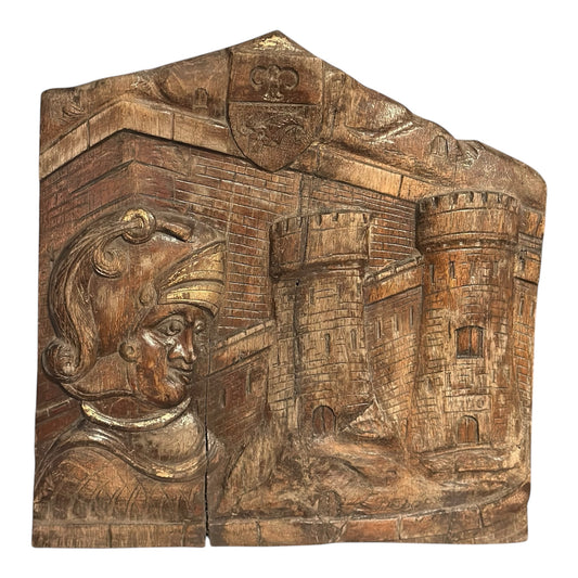 Hand-carved early 20th-century folk art oak panel depicting a Roman soldier, castle turrets, and a coat of arms, indistinct signature lower right