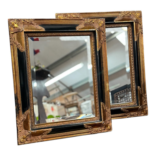 Elegant pair of mid-20th century gilt and black beveled mirrors with a classic design